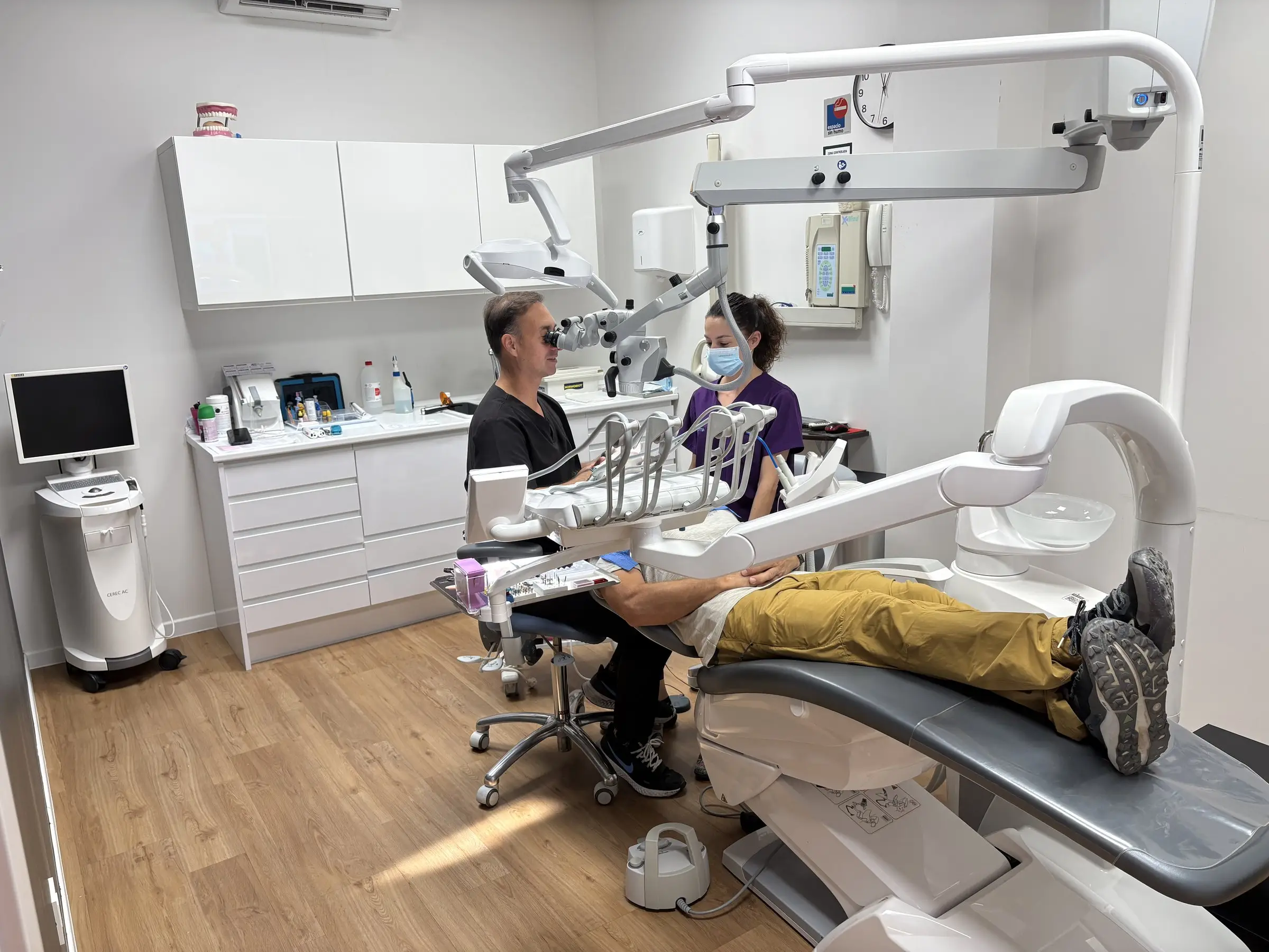 Doctor de Salud Total realizando un tratamiento con microscopio dental